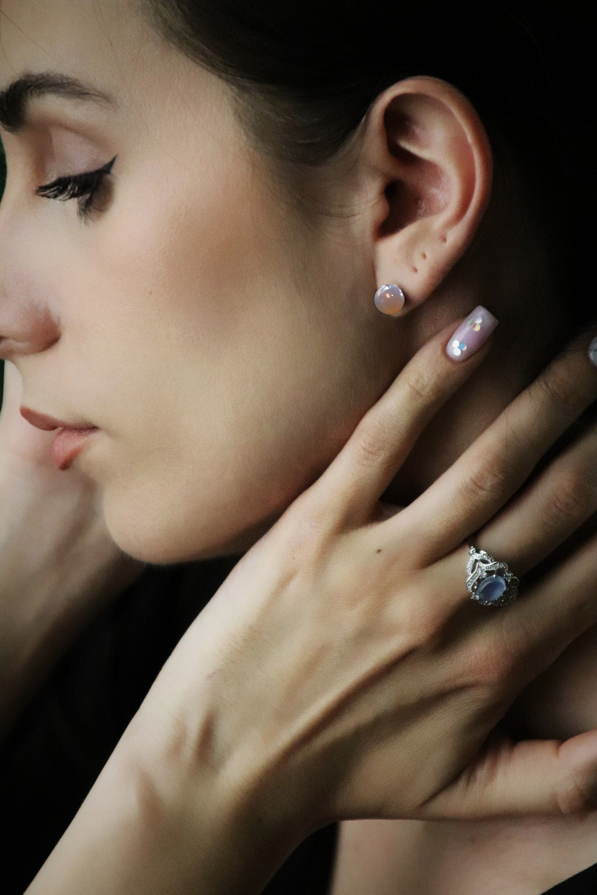 woman wearing grey agate earrings and aquamarine ring