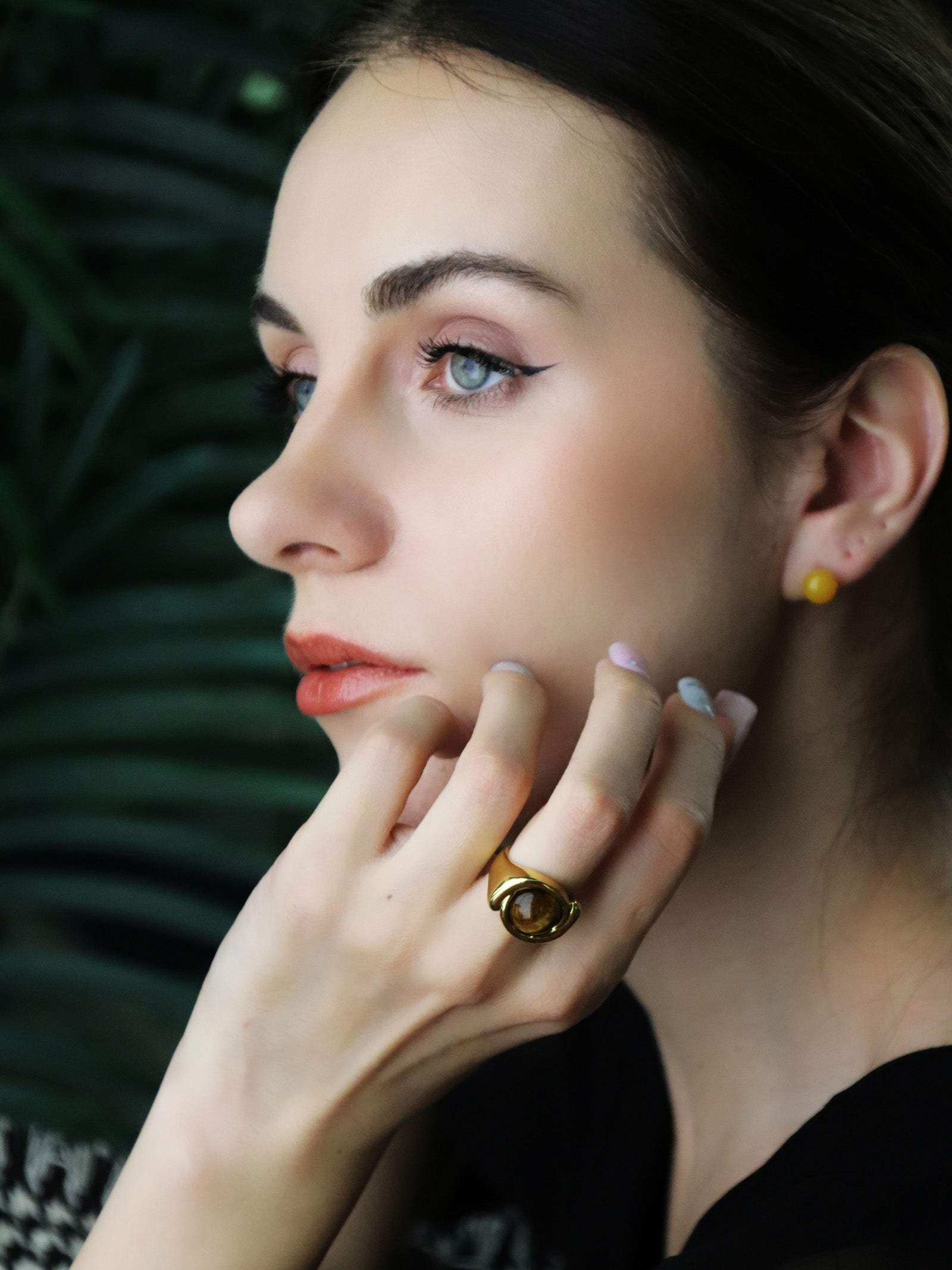 woman wearing natural agate earrings and tiger's eye ring