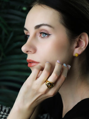 woman wearing natural agate earrings and tiger's eye ring