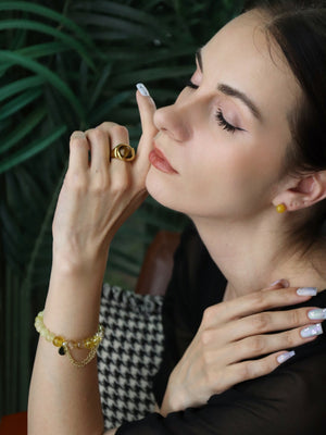 Woman wearing citrine bracelet, the sun earrings, and tiger's eye ring for confidence and wealth