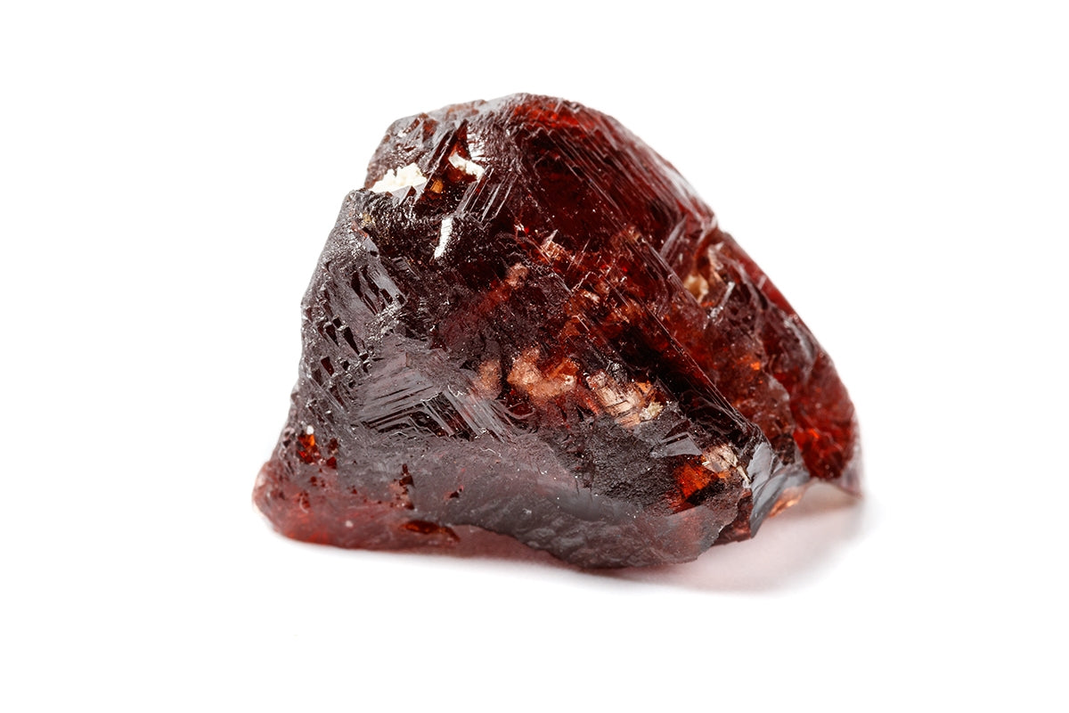 Raw garnet mineral with deep red facets and earthy matrix, gemstone of passion and vitality