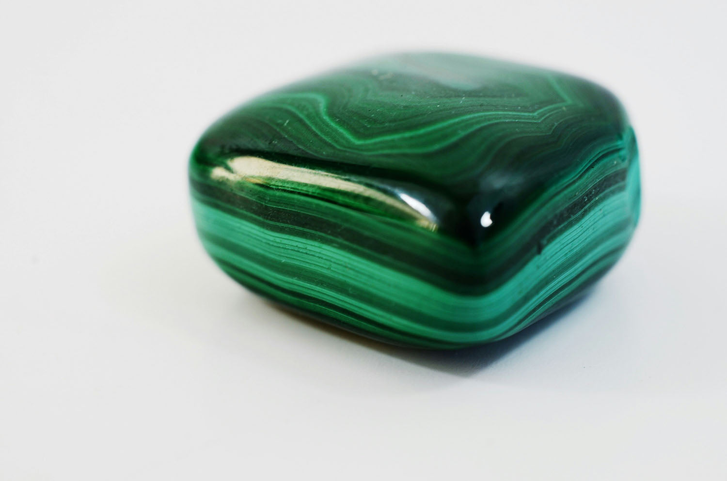 Polished malachite stone with green banded patterns, crystal of transformation and healing