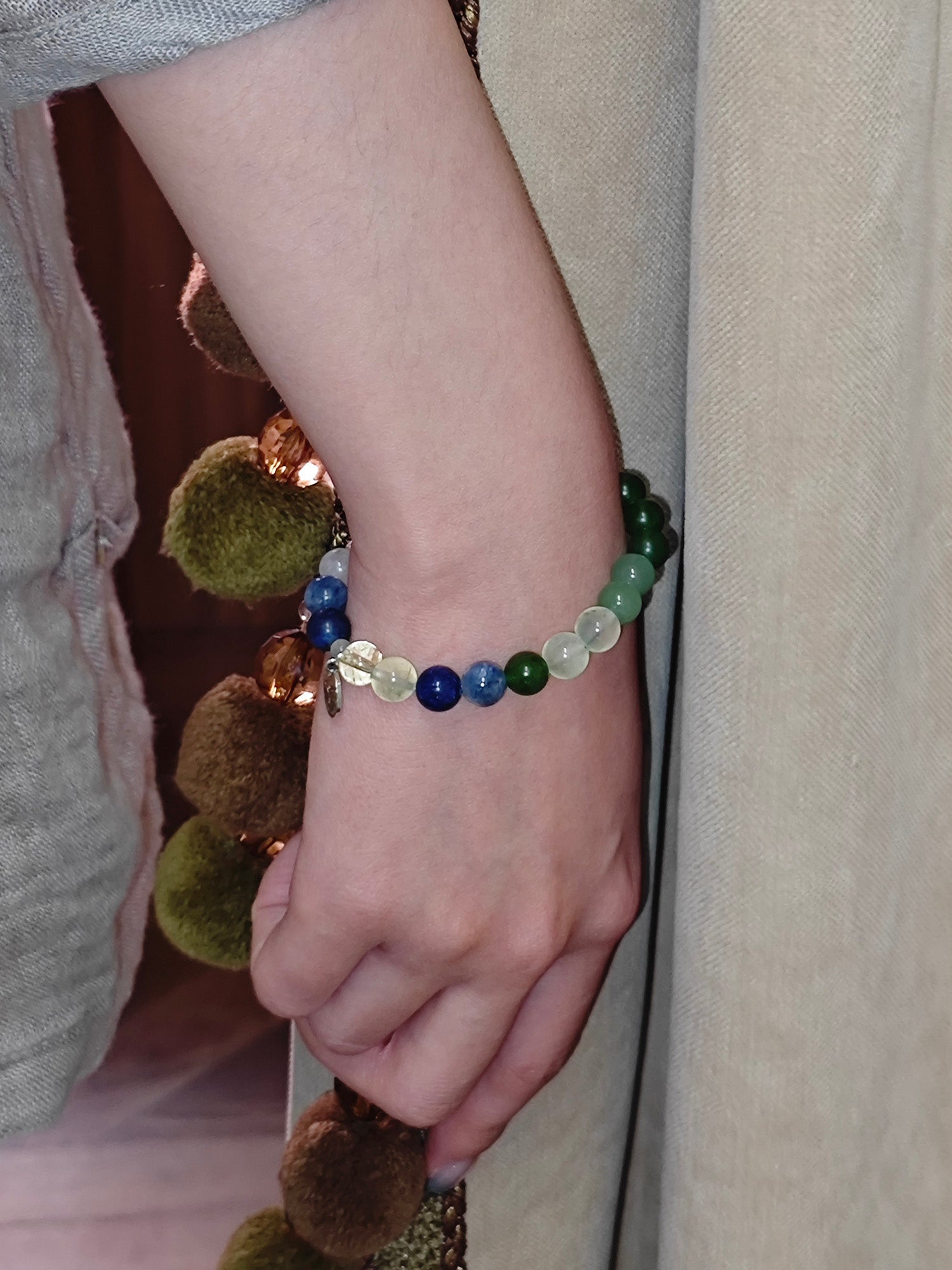Close-up of a wrist wearing a beaded bracelet with natural crystals