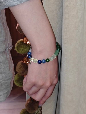 Close-up of a wrist wearing a beaded bracelet with natural crystals