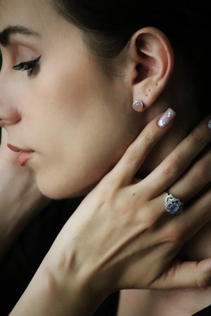 woman wearing grey agate earrings and aquamarine ring