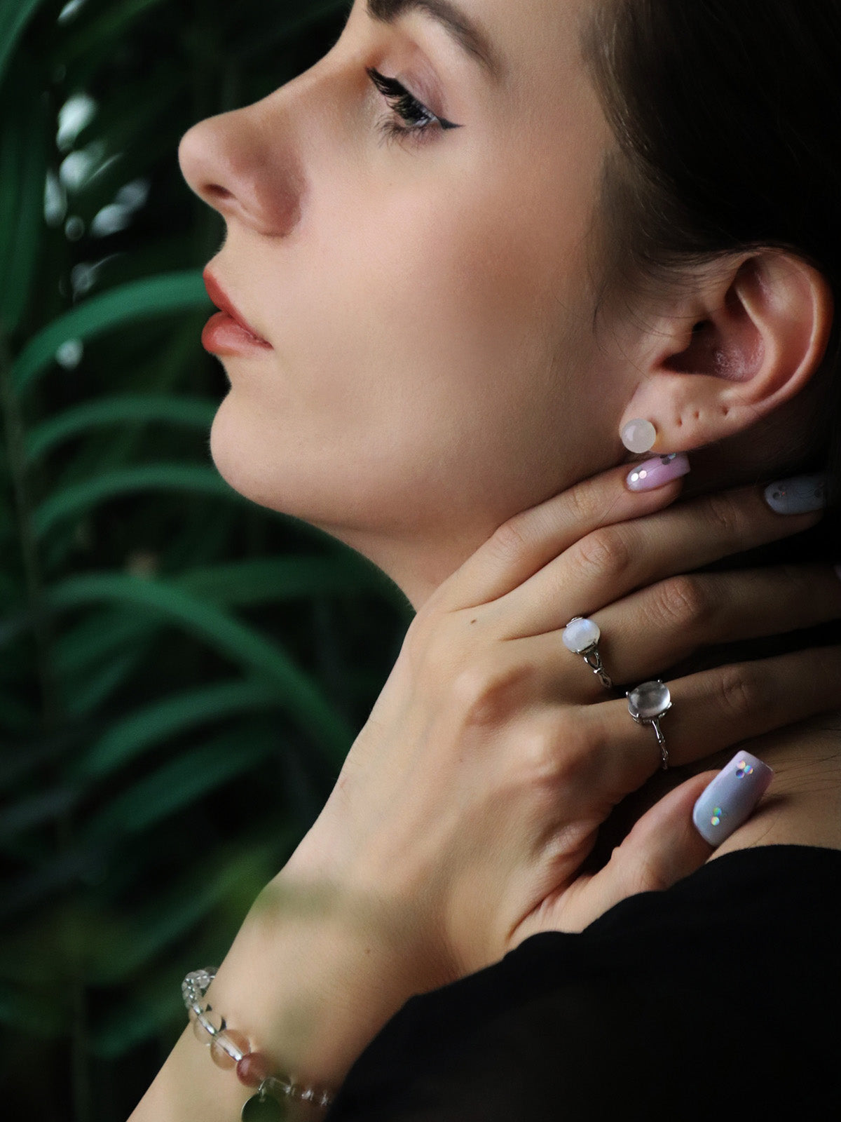 woman wearing clear quartz earrings and natural crystal rings