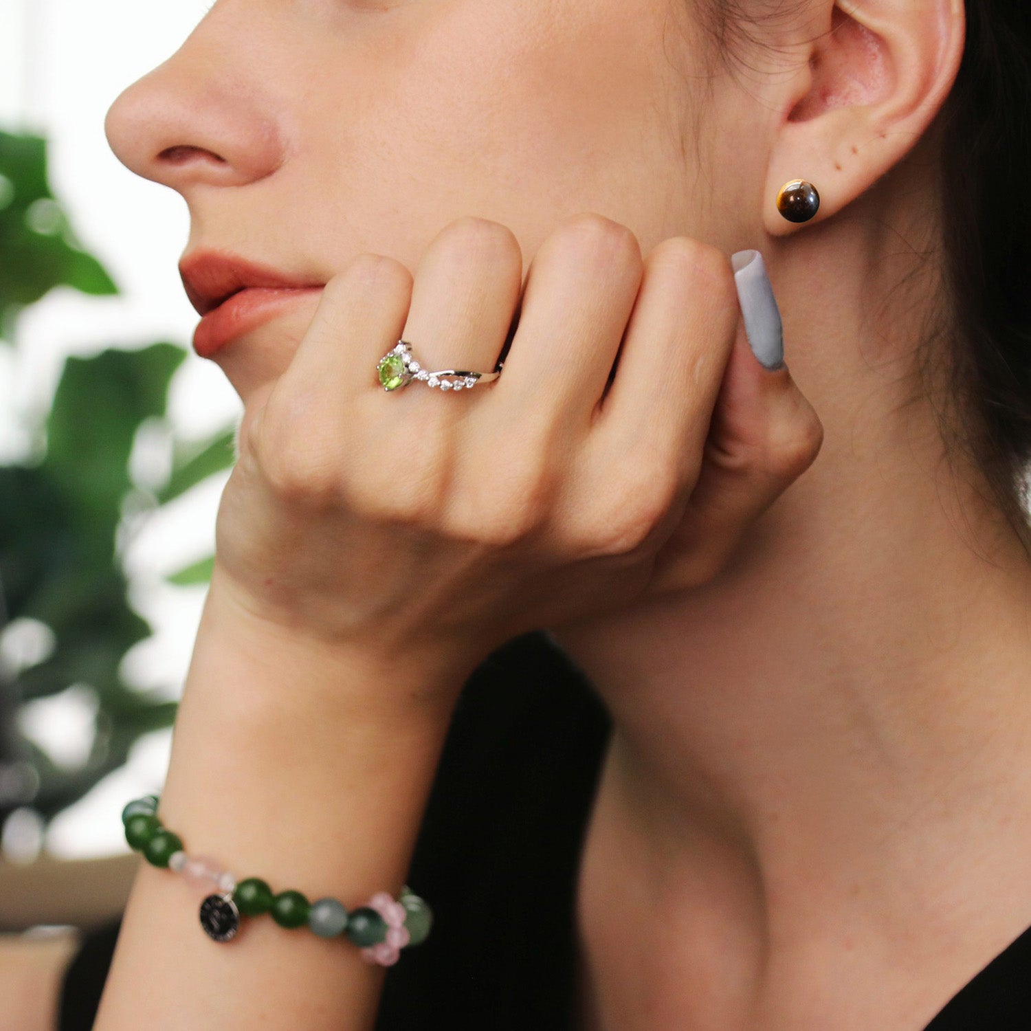 woman wearing Saturn - Tiger Eye Sterling Silver Earrings, jade bracelet and Peridot ring