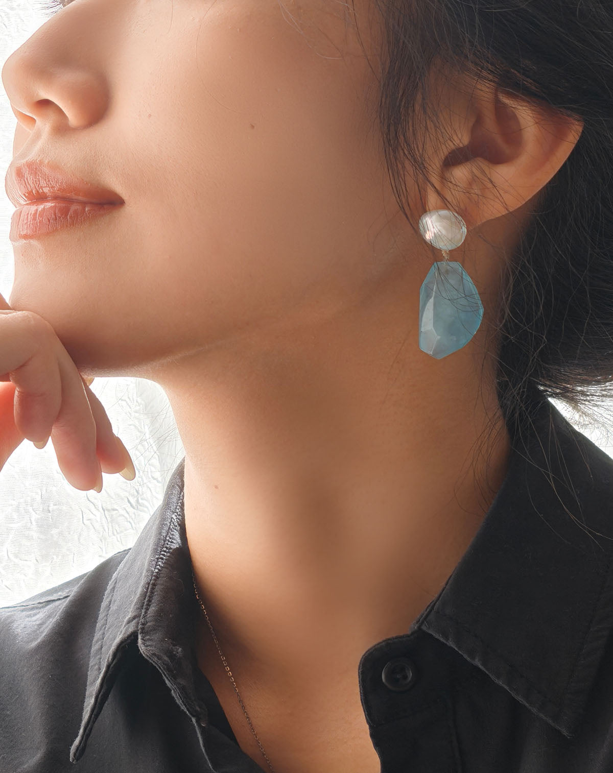 Model wearing aquamarine and pearl earrings, elegant everyday style jewellery UK